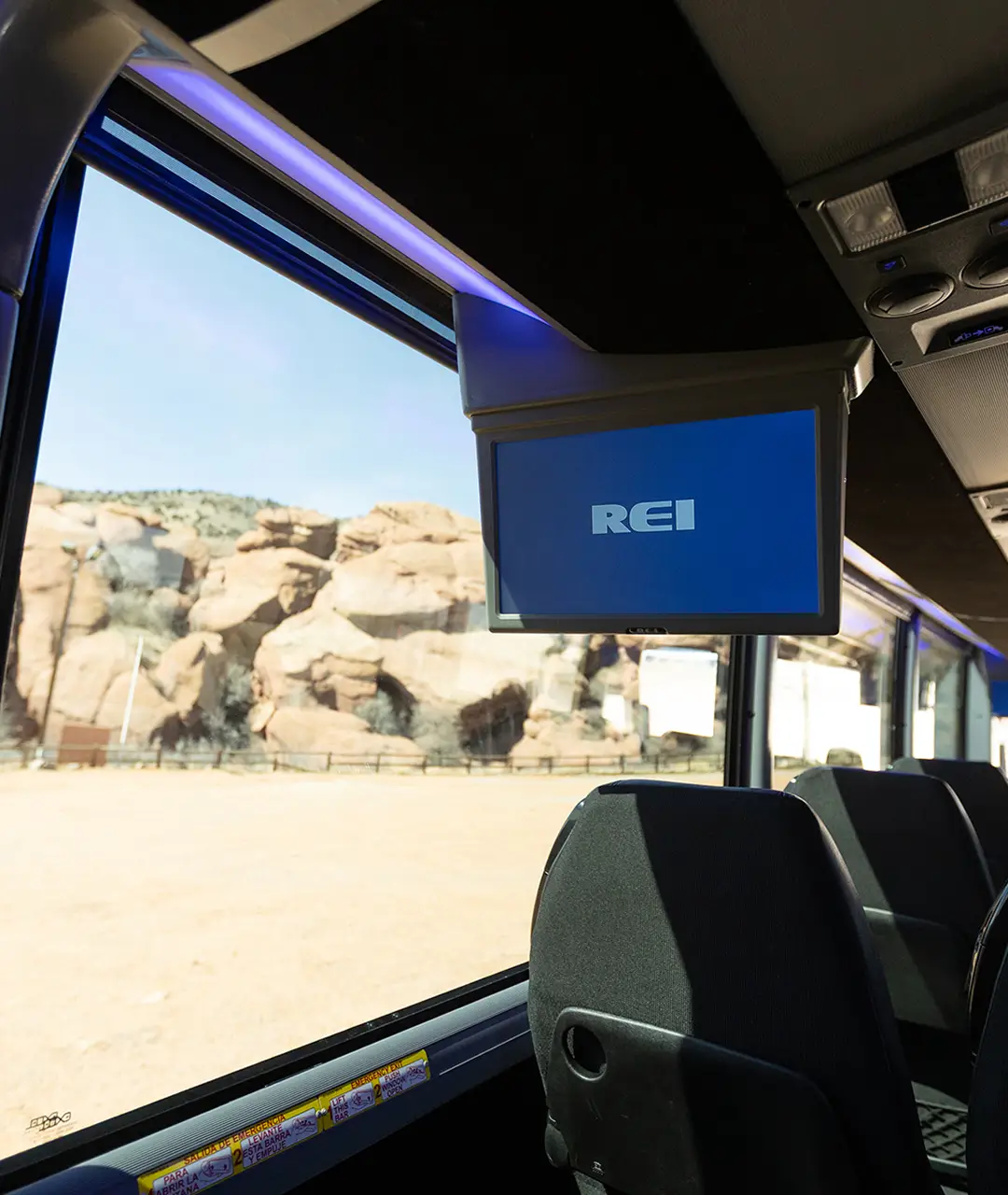 Interior of Ace Express Coaches motorcoach showing REI screen and large window with scenic landscape.
