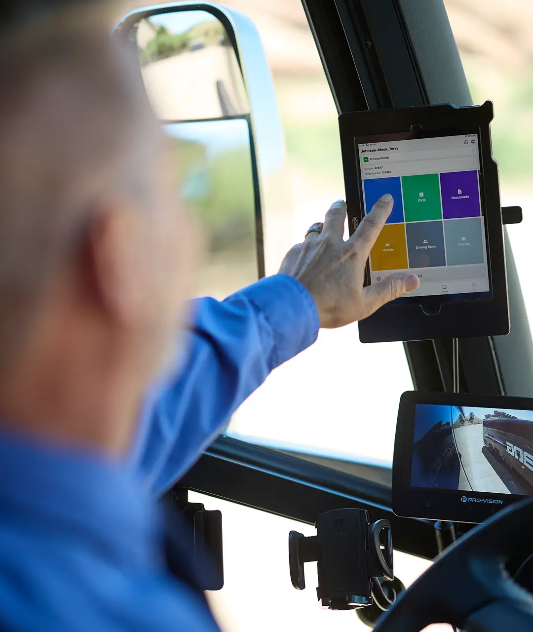 Driver using a tablet with dispatch software inside an Ace Express Coaches motorcoach.