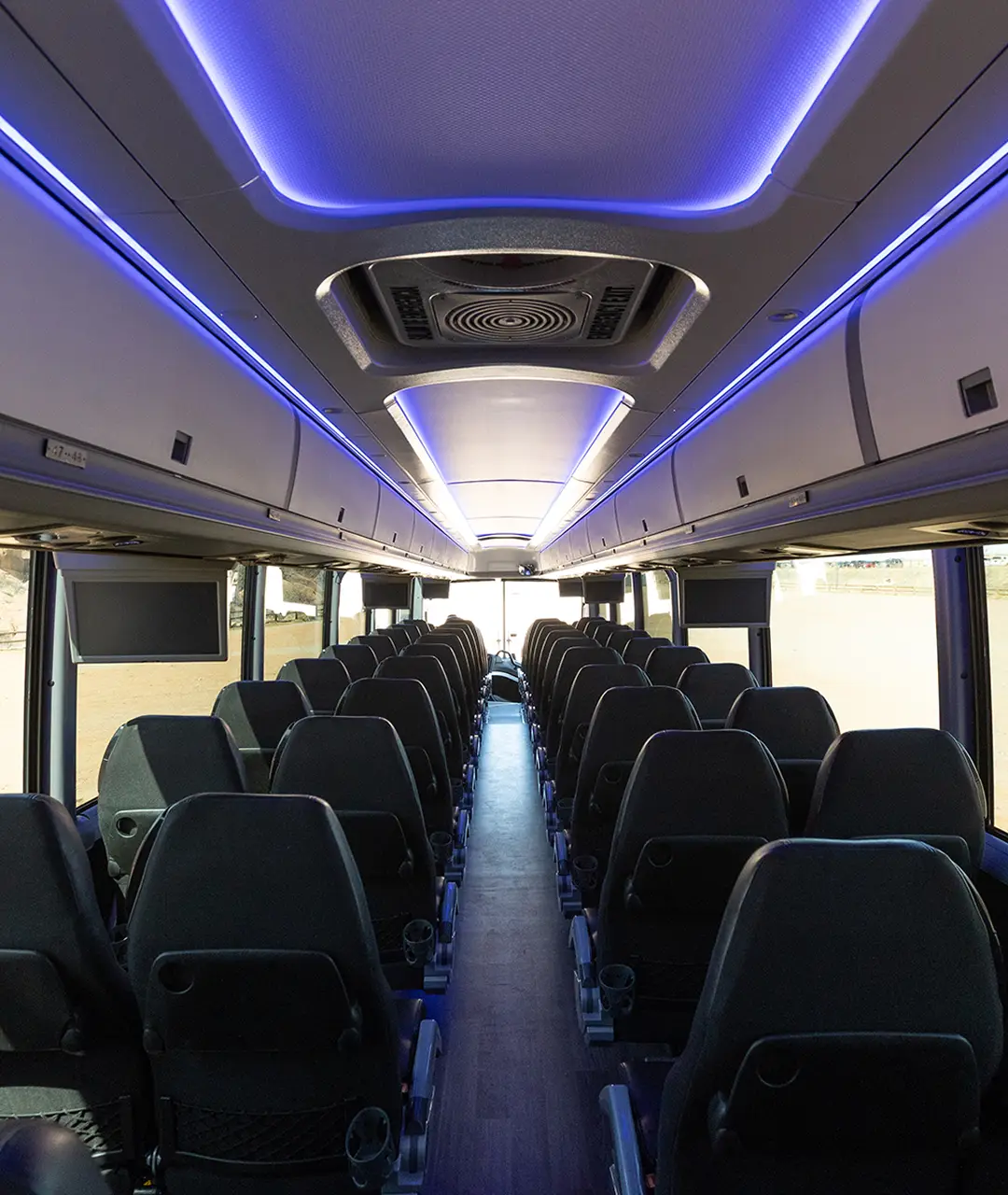 Interior view of a modern motorcoach with LED lighting, comfortable seats, and large windows.