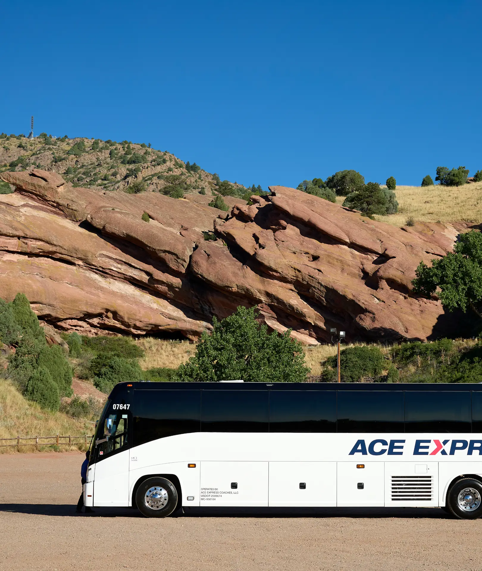 ACE Express Coaches motorcoach on scenic route near red rock formations.