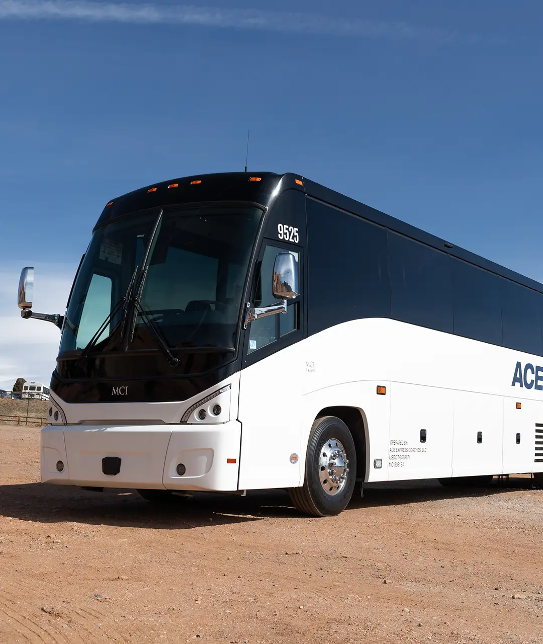 Modern black and white coach motorcoach parked outdoors.