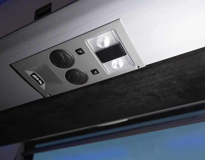 Close-up of luxury motorcoach interior control panel with lighting and buttons.