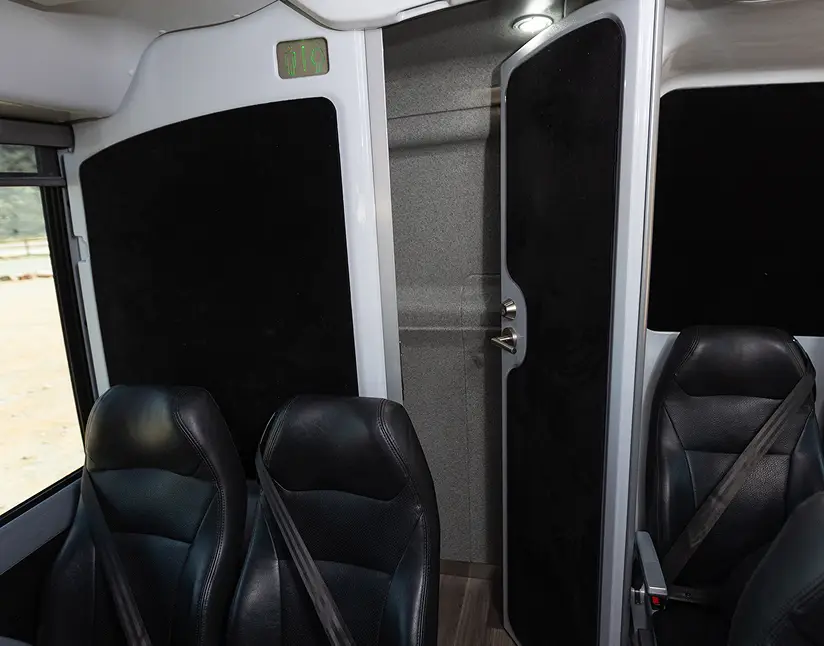 Interior view of Ace Express Coaches motorcoach with black leather seats and door.