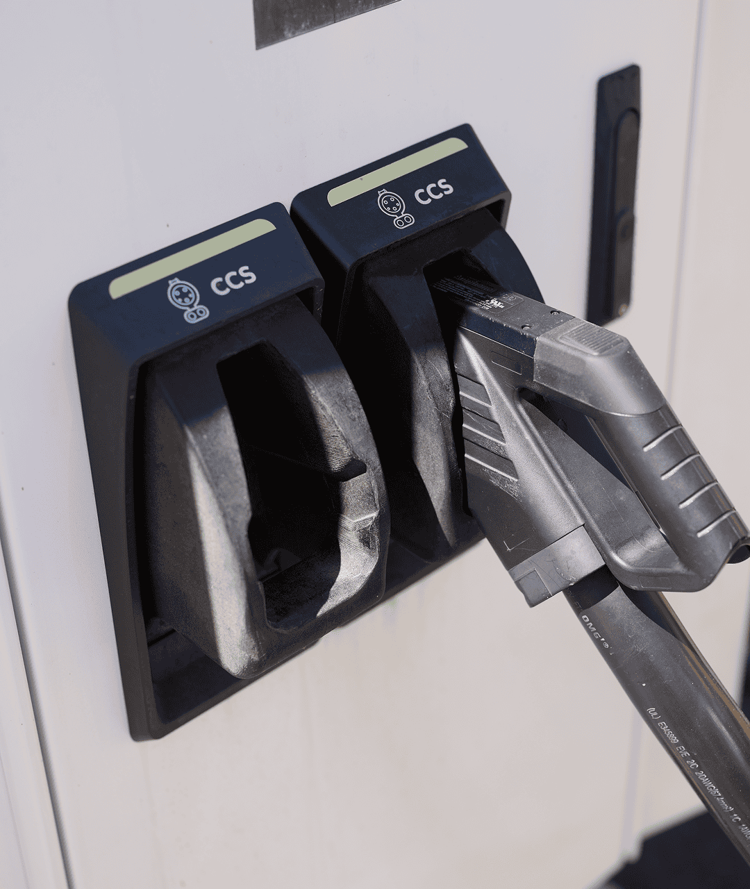 Electric vehicle charging station with two charging ports and a charging cable.